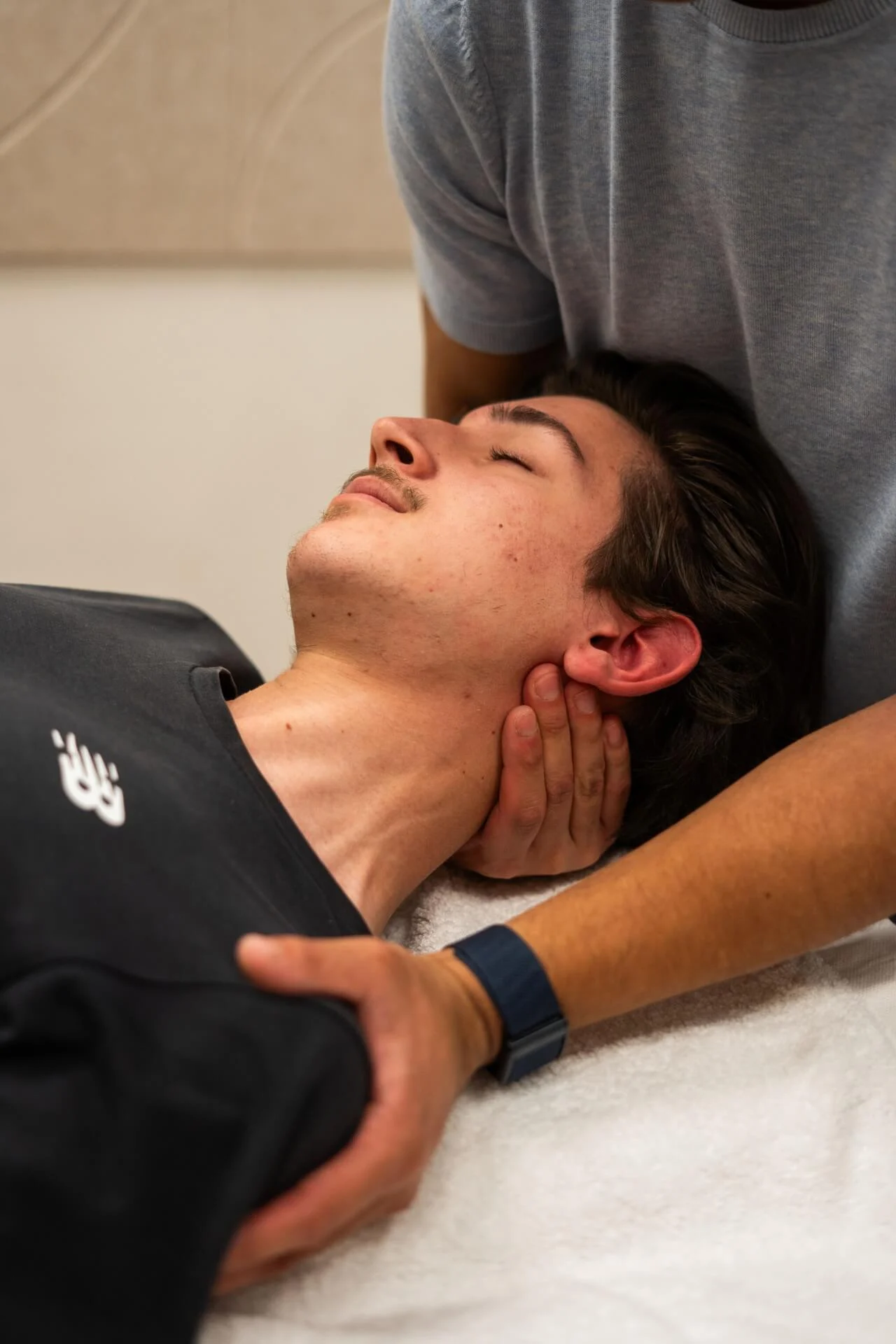 Fysiotherapeut behandelt de nek en schouder van cliënt tijdens fysiotherapiesessie bij Feel Fit Lochem.