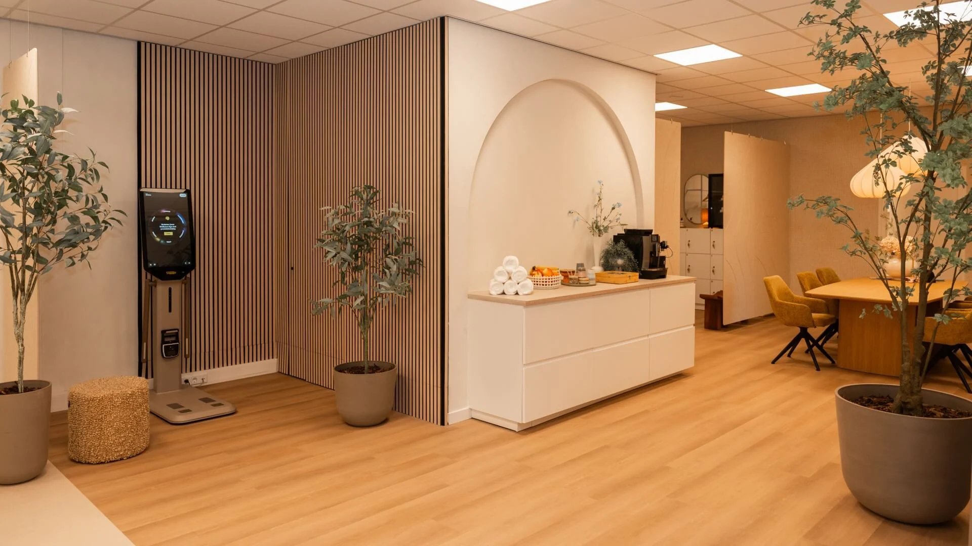 Loungehoek met Technogym-checkup apparaat, koffiecorner en warme inrichting bij Feel Fit Lochem.