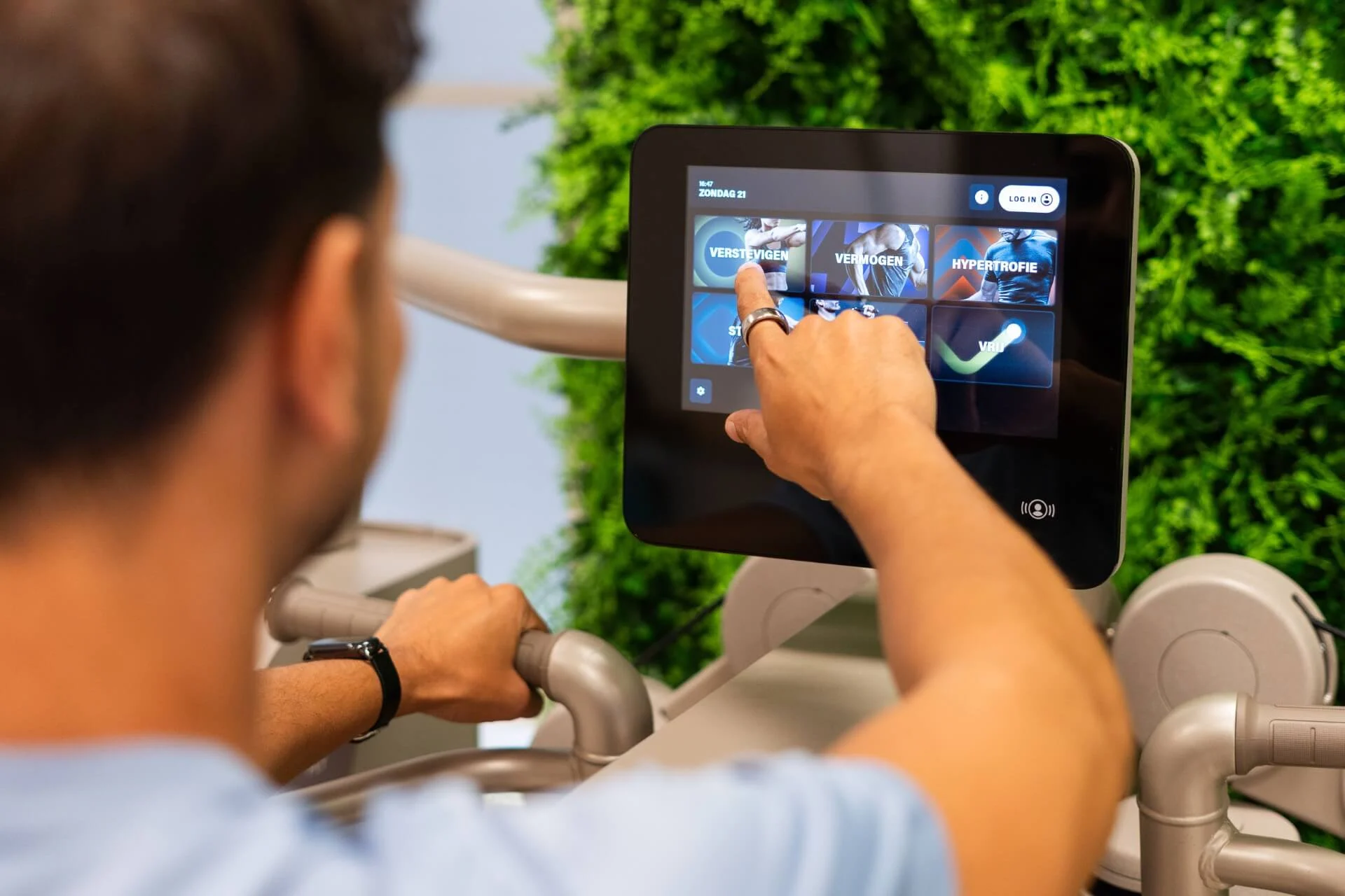 Sporter kiest persoonlijk trainingsprogramma op Biostrength touchscreen bij Feel Fit Lochem.
