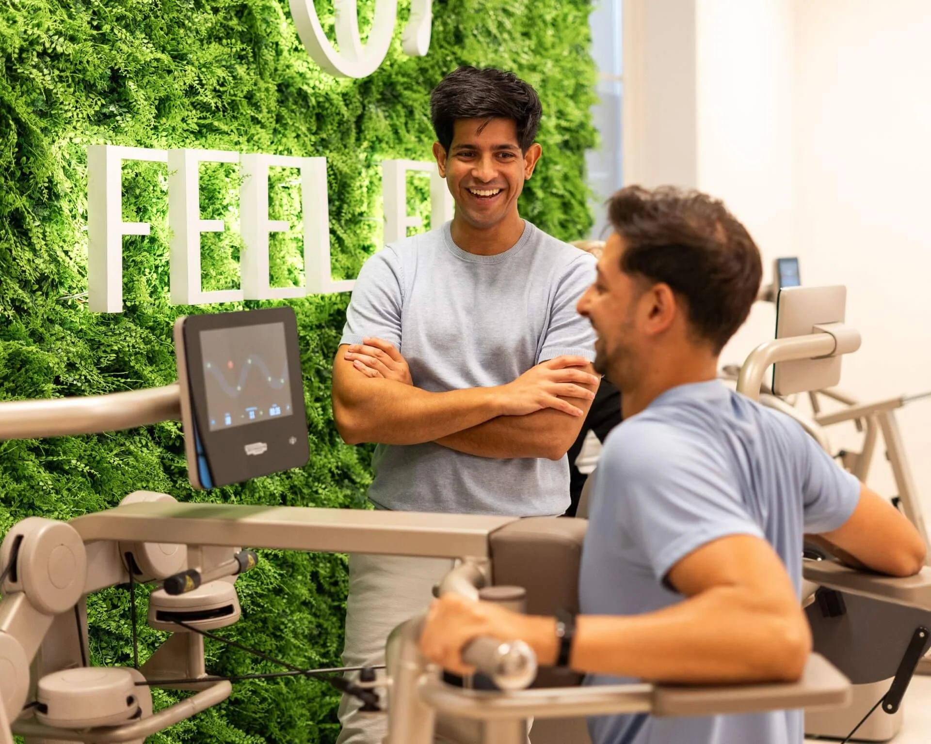 Trainer begeleidt sporter tijdens krachttraining op Biostrength toestel bij Feel Fit Lochem.